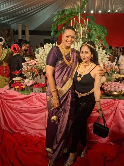At the 'Art of Adornment' event, surrounded by beautiful floral decor. My classic purple Kanjivaram silk saree was chosen to honor the theme of timeless Indian elegance.