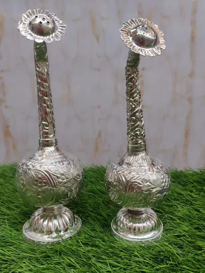 A pair of German silver paneer daani (rose water sprinklers), with detailed carvings, used in traditional welcome rituals and poojas.