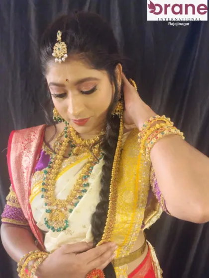 This traditional bridal look features a classic long braid adorned with accessories. We teach our students various braiding techniques and how to securely add embellishments for a flawless finish.