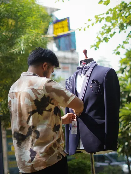 Every suit I create is a personal journey. Here I am adding the final touches to a bespoke navy blue tuxedo, ensuring the fit and details are absolutely perfect for my client.
