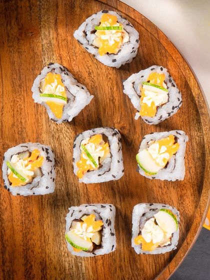 An overhead shot of the Cucumber Cream Cheese rolls scattered on a wooden platter.