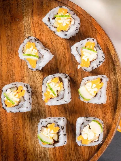 An overhead shot of the Cucumber Cream Cheese rolls scattered on a wooden platter.