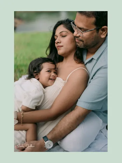 A warm family embrace. The little one is held securely between his parents, a perfect picture of love, comfort, and family connection.