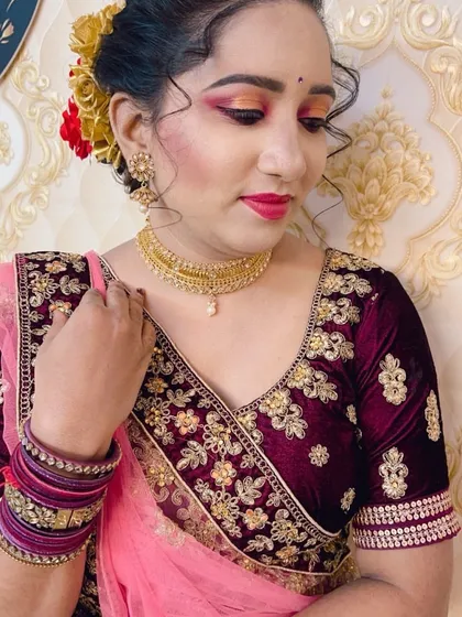 A side view of the engagement look, showing the hairstyle adorned with red and yellow flowers. The makeup is soft and glowing.