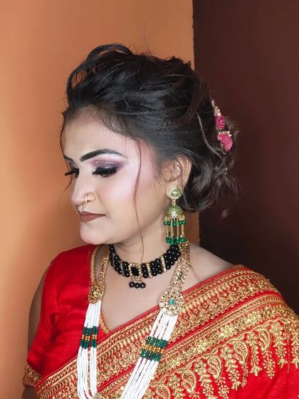 A side view highlighting the elegant updo and the long, traditional earrings.