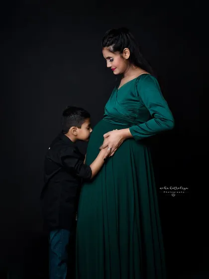 Welcoming a new baby is a family affair. This heartwarming shot shows a big brother-to-be giving his future sibling a gentle kiss on the baby bump, a beautiful memory for the whole family.