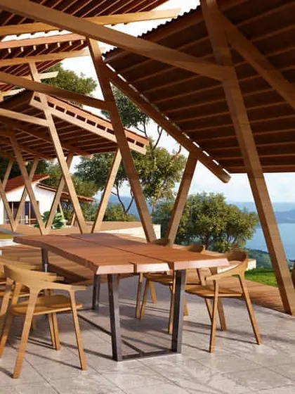 A residential project in Lonavala, featuring a covered outdoor dining area with an expansive view of Pavna Lake. The design utilizes a diagrid roof structure and natural wood to create a seamless connection between the built environment and the surrounding landscape.