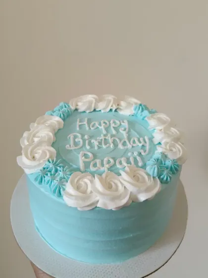 A simple and sweet birthday cake in blue with white piped rosettes.