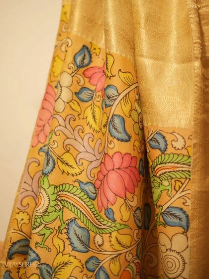 A detailed view of the Kalamkari pallu, where the lotus and bird motifs are painted with natural dyes, making each saree unique.