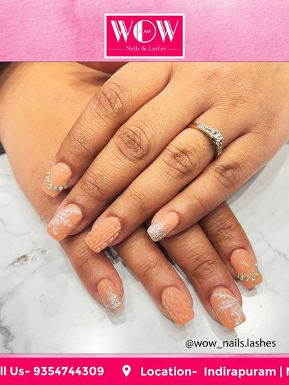 This textured nail art on square extensions combines a soft peach color with glitter accents and 3D patterns. It's a unique and tactile design for those who want something different.