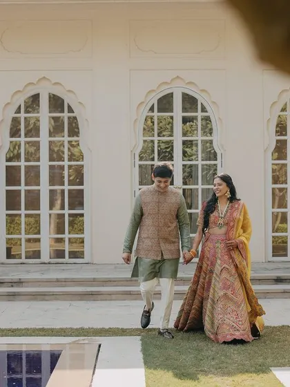 A candid shot of the couple walking through the beautiful grounds of the venue. The framing through the leaves adds a natural, intimate feel to the photograph.