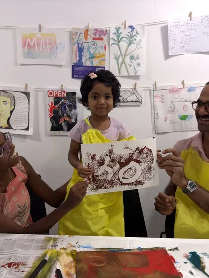 A proud family shows off the print they created together at the Colourful Connects workshop. These collaborative art projects are a wonderful way to build lasting memories.