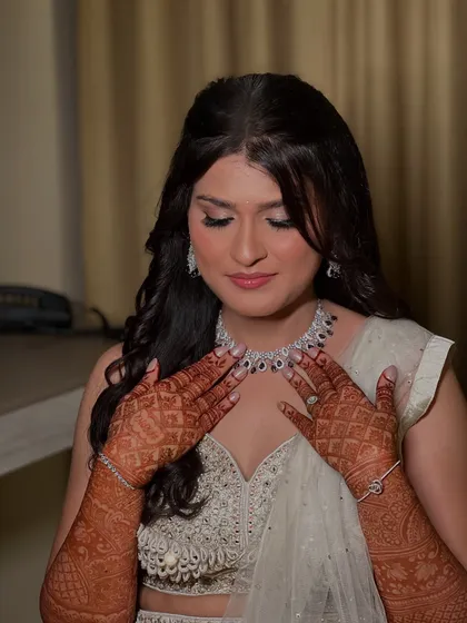 A close-up of Prerna's Sangeet look, showing her dramatic winged eyeliner and the intricate henna design.