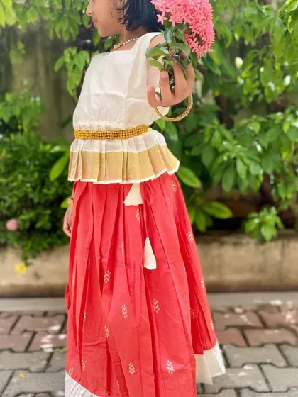 The Nila set is all about elegance and comfort. The peplum top with a Kasavu border pairs beautifully with the peach skirt, and the entire outfit is made of soft cotton to keep your little girl happy.