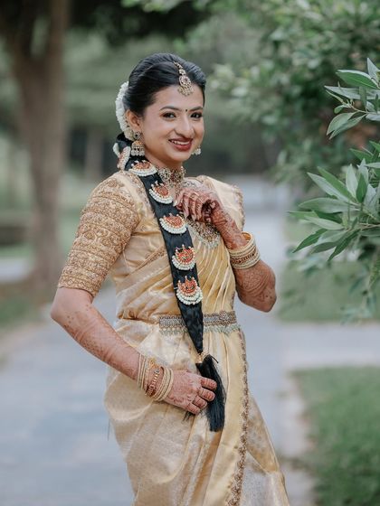 A full-length view of the bride with her traditional braided hairstyle, adorned with beautiful accessories.