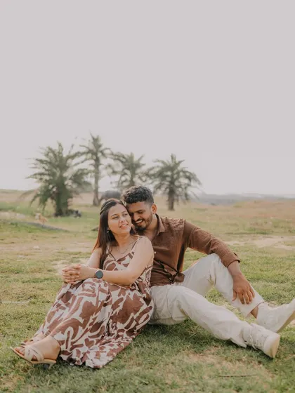 A sweet and relaxed moment of the couple enjoying each other's company in a beautiful outdoor setting. The composition is simple and focuses on their connection.