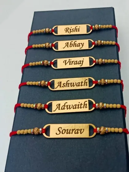A simple and classic option: our customized name rakhi with a traditional red dori. We can engrave any name on the polished golden plate.