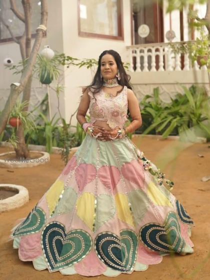A client looking lovely in the heart-patterned lehenga at an outdoor event.