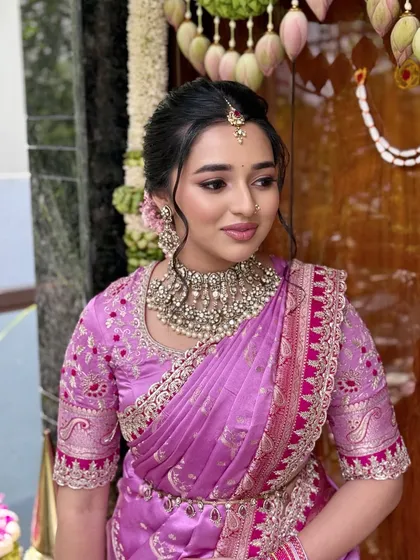 A side profile showcasing the soft, romantic updo and the intricate embroidery of her blouse.