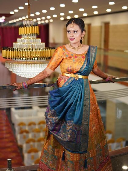 A beautiful shot of Yoshitha at her event, with a grand chandelier in the background. Her makeup is bright and fresh to match the festive atmosphere.