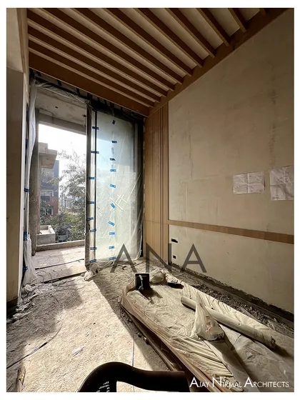 A view of the wood-paneled ceiling and wall details being installed at the DLF Phase 1 residence. This shows the early stages of layering materials to create a contemporary aesthetic.