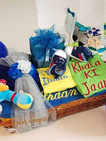This adorable hamper was a special gift from a 'Khala' to her newborn nephew. It's filled with goodies like a custom towel, a cute romper that says 'Khala Ki Jaan', tiny shoes, and toys, all packed into a beautiful basket.