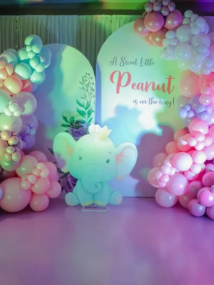 "A Sweet Little Peanut is on the way!" This adorable elephant-themed baby shower decor features soft pastel balloon garlands and a cute elephant cutout, creating a gentle and loving atmosphere.