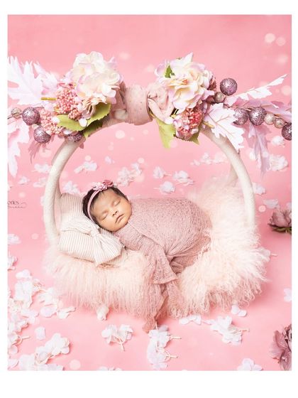 A little princess resting in her floral swing. This pink-themed setup is incredibly sweet and creates a dreamy, fairytale-like portrait.