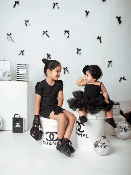 A sweet, interactive moment between the sisters during their fashion shoot. It's a mix of high style and genuine sibling love.
