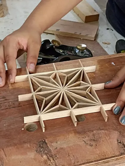 A close-up of the nearly finished Asa-no-ha pattern. The interlocking strips of wood create a beautiful and strong design, all held together by friction and precision.