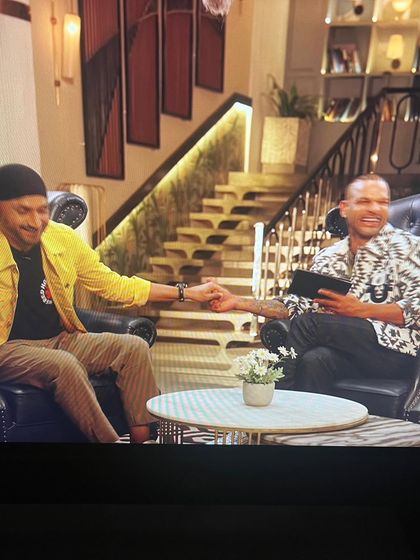 A handshake moment between the two cricket legends, Harbhajan Singh and Shikhar Dhawan, showcasing the smart-casual outfits I put together for their segment.
