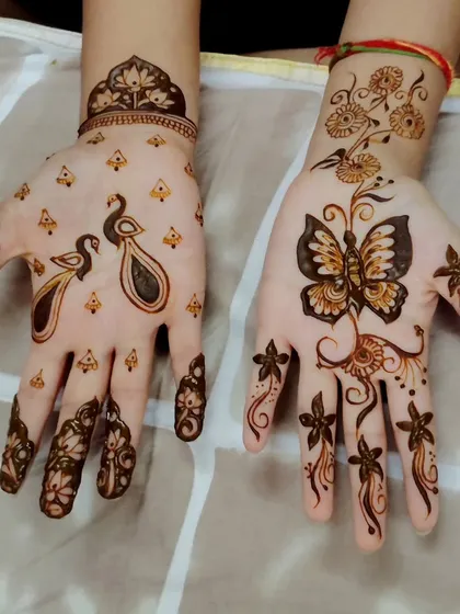 A playful and simple design with a peacock on one hand and a butterfly on the other. This is a great option for someone who wants a unique and less traditional pattern.