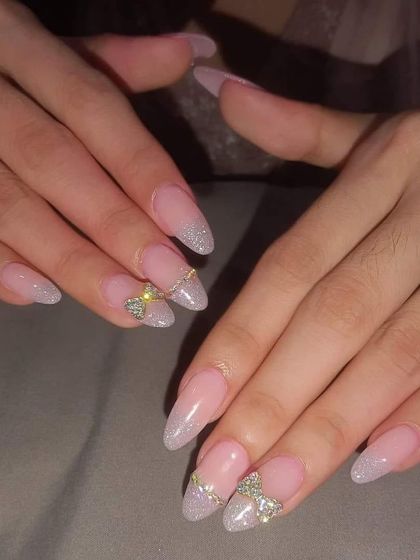 A beautiful and elegant set with a glittery silver French tip and a 3D bow made of sparkling rhinestones.