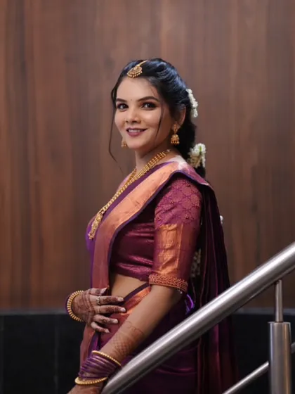 A side profile of the bride, showcasing her complete look from the hairstyle to the elegant drape of her saree.