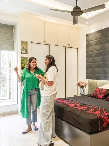 A shot of me and a team member in the bedroom from image 13, discussing the design.