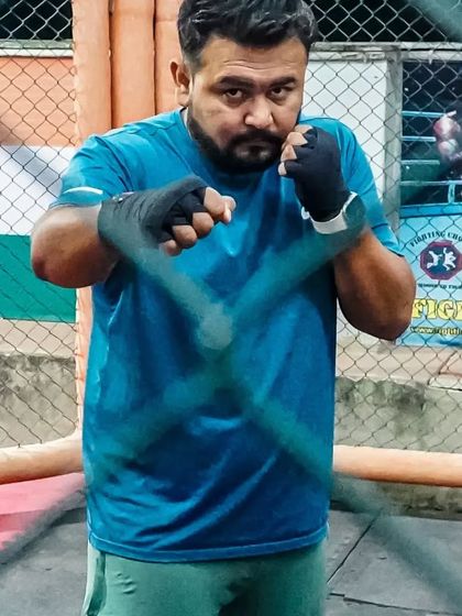 Our coach, wrapped and ready, demonstrating the fighting stance. Leadership by example is a core principle at our gym.