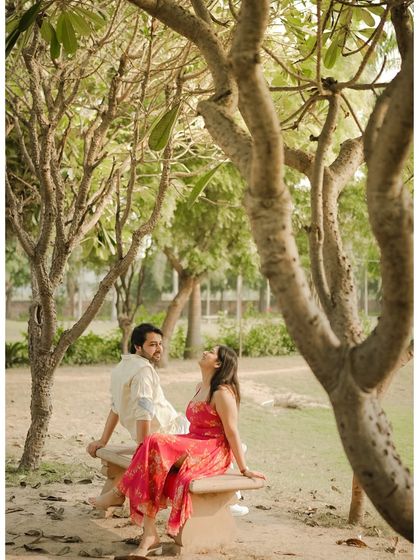 A quiet moment shared on a bench under the cool shade of trees, capturing a peaceful and intimate conversation.