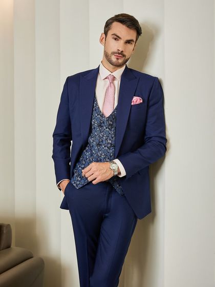 This pose highlights the slim, modern cut of the navy suit. The patterned waistcoat adds visual interest, making it a sophisticated choice for business or formal events.