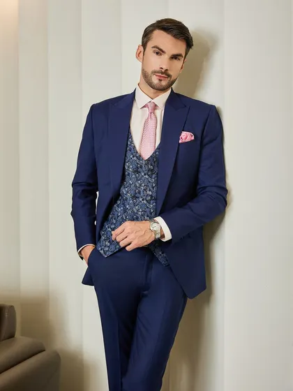 This pose highlights the slim, modern cut of the navy suit. The patterned waistcoat adds visual interest, making it a sophisticated choice for business or formal events.
