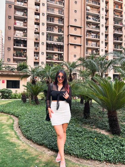 A stylish look with a sheer black top and a white ruched skirt from NewMe. This is a great outfit for a brunch or a day out.