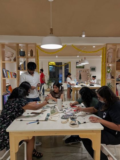 A busy session at the studio, where participants are working on various craft projects at a long table.