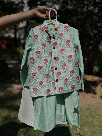 Here is the same quilted Nehru jacket set in a refreshing mint green. The floral print adds a touch of elegance, making it a perfect choice for summer weddings and celebrations.