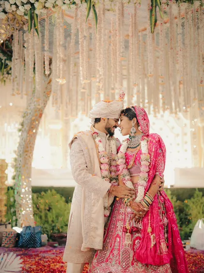 A romantic moment under a canopy of flowers. We capture the couple in a gentle embrace, surrounded by the beautiful wedding decor.