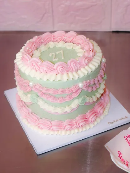 Delicate piping, graceful frills, and a whole lot of vintage love. This sage green and pink cake with pearl details is perfect for bringing timeless elegance to your table.
