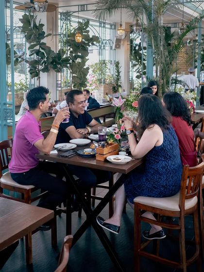 A group of friends engaged in lively conversation around a table at Roxie, the perfect setting for a get-together.
