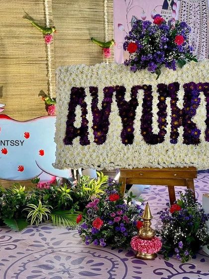 A detailed look at the custom floral name board for "Avyukth," created with white and purple flowers. This piece served as a beautiful focal point and a personalized element of the decor.