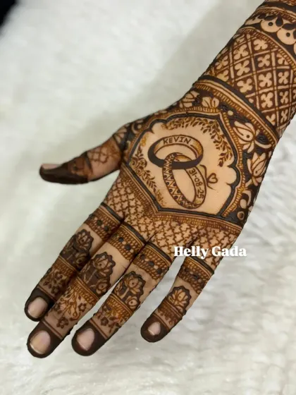 A close-up of the engagement ring motif. The two rings are interlocked with the couple's name and wedding date, creating a beautiful and personal symbol of their union.