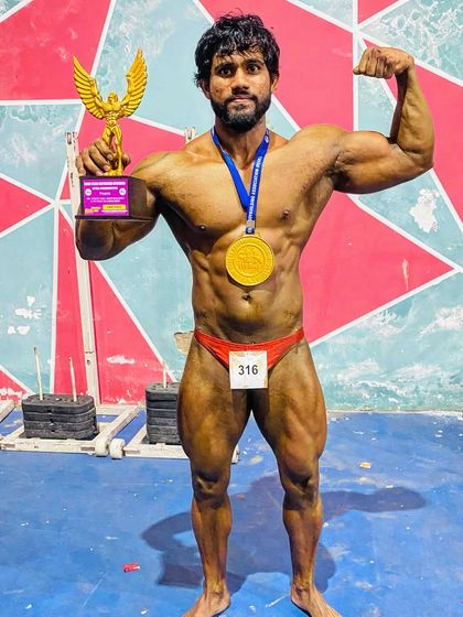 Holding the gold medal and trophy from the Mr. North India championship. This is the look of a champion who has earned his title.