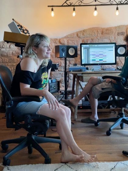 A candid shot of a vocalist during the Spain sessions, listening intently. Every member of the collaboration is deeply engaged in the music.