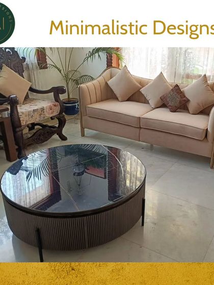 A minimalist living room setting featuring a soft beige sofa and a fluted round coffee table with a dark marble top. This pairing exemplifies our approach to creating serene spaces that balance texture, form, and function.